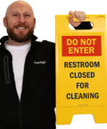 Do Not Enter Restroom Closed For Cleaning Two Sided Folding Floor Sign Plastic Heavy Duty Durable 25 By 12 Inches Red Black Yellow High Visibility Double Sided For Busy Hallways And Maintenance Areas, shown held upright