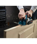 Six And A Half Amp Planer With Aluminum Front And Rear Shoes Three And A Quarter Inch Cutting Width Separate Inch And Metric Depth Scales Ball Joint Cord Swivel For Easy Positioning Factory Reconditioned For A Smooth Accurate Finish in use on a door