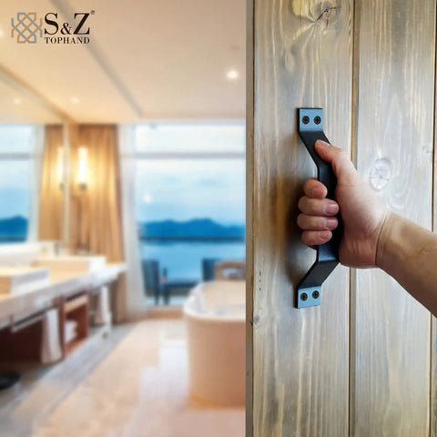 Hand gripping 9 Inch Sliding Barn Door Handle Set In Black Frosted Finish, Heavy Duty Carbon Steel Door Pull, installed on wood door.
