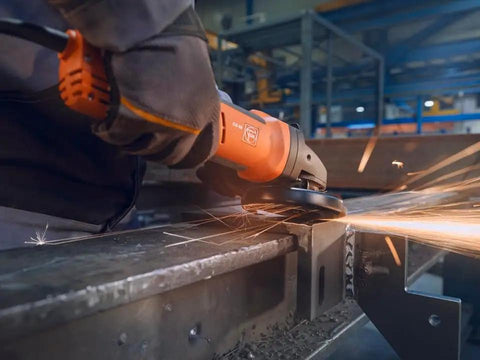 Beefed Up Brushless Angle Grinder With 125Mm Disc And 1500W Motor Variable Speed cutting metal with sparks flying in workshop.