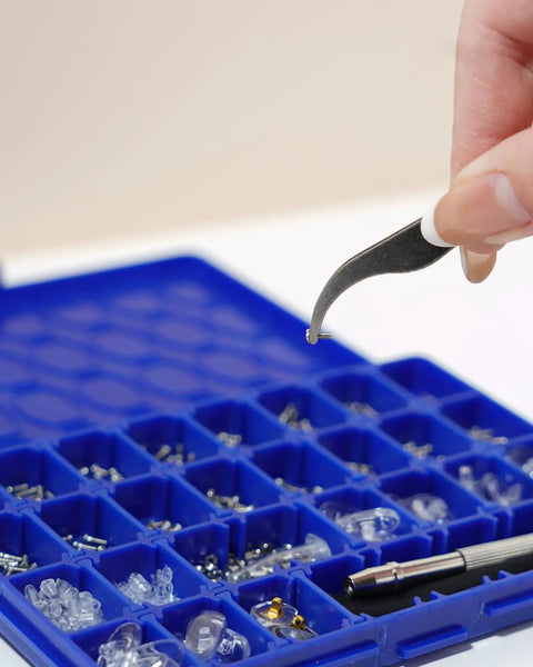Complete Eyeglass Repair Kit With 1000 PCS In 32 Slot Blue Case featuring tweezers selecting a rust-proof screw.