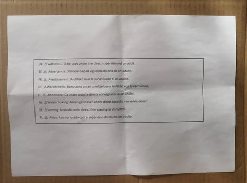 White paper with multilingual safety warnings for adult supervision on cardboard background.