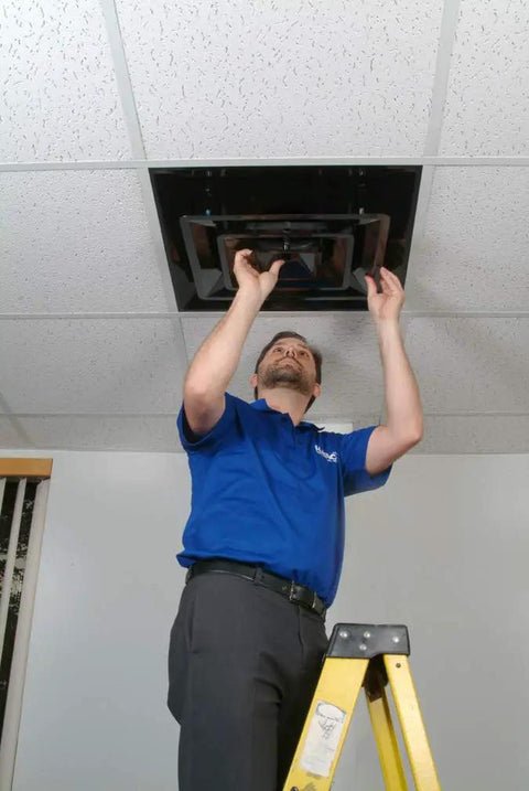 Technician installing Lay In 2x2 Foot 3 Cone Supply Diffuser with 6 Inch Pre Molded Boot on ceiling grid