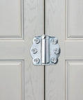 Solid As A Rock Self Closing Door Hinges 3 Piece Set Corrosion Resistant Zinc Springs mounted on a light gray cabinet door.