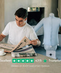 Man reads newspaper next to Automatic Ironing Machine 4.0 for Home Use, Hands Free Wrinkle Remover and Clothes Dryer with shirt form.
