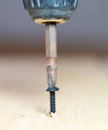 Close-up of a drill driving a Beefy Set Of 100 8 By 1 Inch Wood Screws Self Tapping Truss Head Phillips Stainless Steel 304 Black Oxide.