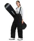 Woman wearing Womens Baggy Ski Bibs And Snowboard Pants Waterproof Windproof Insulated Overalls with snowboard