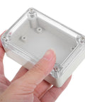Top Tier 6 Pack Waterproof Electrical Box Enclosure With Clear Transparent Cover For Security Modules And Systems held in hand.