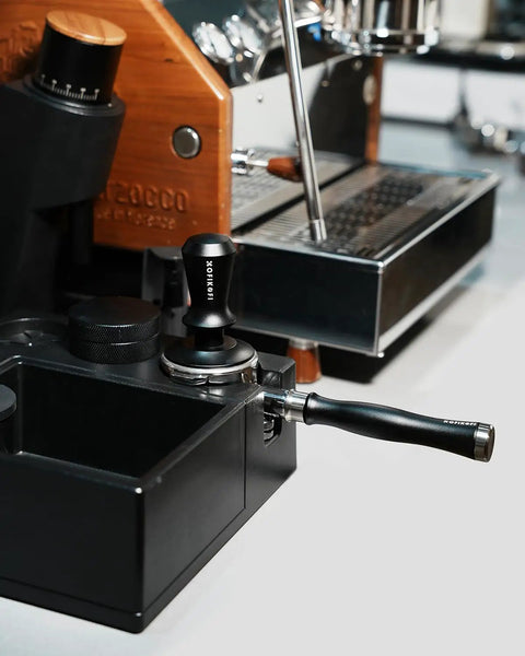 Kickstart Your Brew Routine With Top Shelf 58mm Bottomless Portafilter featuring aluminum handle near Breville espresso machine.