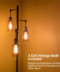 Three-Head Industrial Farmhouse Floor Lamp With Amber Glass Shades glowing warmly against a yellow wall.
