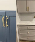 Gold Zinc Alloy Drawer Pulls 4.2 Inch Long Cabinet Handles installed on blue and grey cabinets, shown with included screws for dressers.