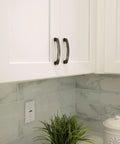 Solid Zinc Alloy Kitchen Cabinet Pull Handle in Oil Rubbed Bronze Simplicity Series installed on white cabinet doors.