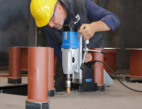 Heavy Duty Portable Magnetic Drill Press With Four Gear Speeds And Hardcore Drilling Power For No Sweat Job Site Work Up To Three Inch Holes And Ten Inch Stroke On Steel Plates in use on a construction site.