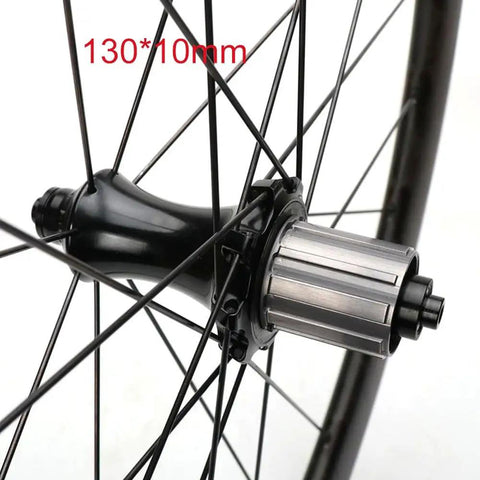 Close-up of beefy aluminum hub on 700C carbon fiber wheelset with 50mm fat rim for road bikes, rear 130mm quick release.