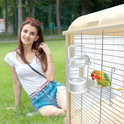 Automatic Bird Water Feeder With Secure Anti Tip Bowl For Small Cages hanging on a birdcage with a parakeet.