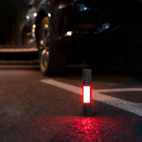 Rechargeable Magnetic LED Flashlight 1000 Lumens with red light on ground beside car at night