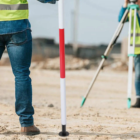 Built Tough Aluminum Prism Pole Shoe With Flat End For Precise Readings, shown on a field survey site, providing stability