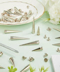 Killer Silver Cone Spike Studs 30 Piece Screw Back Rivet Kit 40Mm And 20Mm on a mint green surface with a screwdriver.