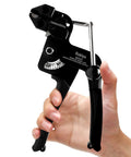 Hand holding All Metal Zip Tie Gun With Cutter For Quick Cable Tie Tensioning; black, metal tool with ergonomic grip.