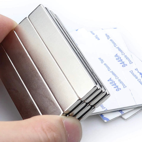 Close-up of 16-pack neodymium bar magnets with double-sided adhesive backing, 60 x 10 x 3 mm, silver metal