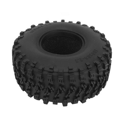 Close-up of a rugged off-road tire viewed from the side, showcasing tread design for durability and traction on rough surfaces.