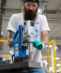 Front view of Hougen HMD900 magnetic drill, 115V, blue base with silver head in use on metal.