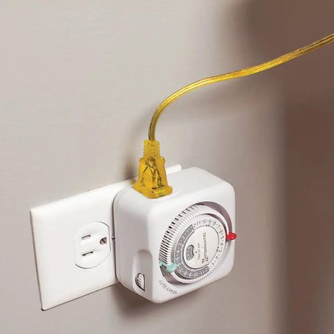 24 Hour Mechanical Plug In Outlet Timer With 15 Amp Indoor Rating providing on-off control for lamps and lights, plugged into a wall socket.