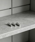 Three nickel-plated spoon shape shelf pegs on a cabinet, part of 80 Pack 5mm Cabinet Shelf Pegs With Spoon Shape Design.