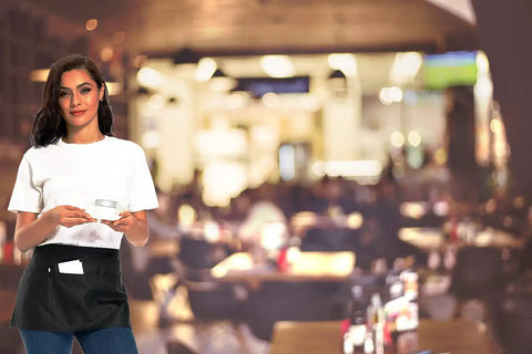 Woman wearing 12 Pack Black Waitress Aprons With 3 Pockets, Waist Aprons For Women And Men in a restaurant setting.