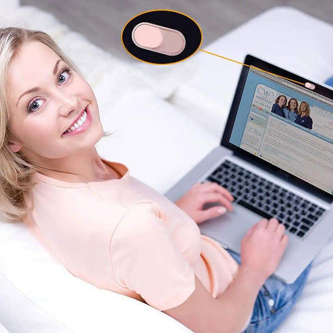 Woman using laptop with a sleek pink slide cover blocking the webcam, ensuring privacy for her setup.