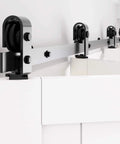 Close-up of black Bi Fold Barn Door Hardware Kit, 79 Inch Track, installed with rollers for smooth closet door movement.