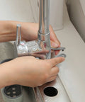 Hands adjusting the adjustable TPR rubber mount of a Double Deck Faucet Mount Kitchen Sink Organizer for easy sponge storage.