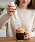 Person using USB Rechargeable Milk Frother Handheld 3 Speed Electric Wand With Digital Display For Creamy Cappuccino Latte Matcha And Hot Chocolate Portable Coffee Mixer For Home Office Travel.