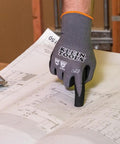 Cut Resistant Nitrile Coated Work Gloves With HPPE, Touchscreen Compatible, ANSI A4, Knit Dipped For Superior Dexterity, Medium Size, 2 Pair Grippy Gloves For Construction, Warehouse, And DIY Projects shown worn on a hand pointing at building plans.