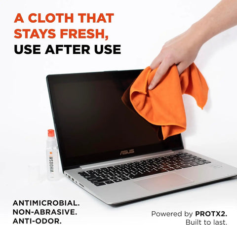 Person cleaning laptop screen with Refillable Screen Cleaner Kit With Microfiber Cloth, 1 Fl Oz Bottle visible beside keyboard.