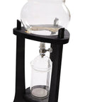 Kick Back And Sip Smooth Chills With This Sharp Cold Brew Drip Coffee Maker Crafted From A Borosilicate Pitcher And Real Wood Stand For Hassle Free Iced Coffee Runs That Come Out Fresh And Totally On Point Daily, showing glass pitcher and wooden stand.