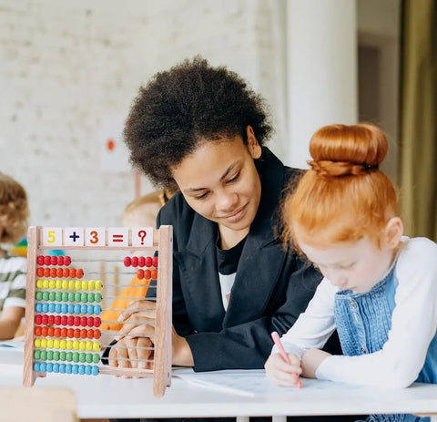 The Real Deal Wooden Abacus For Kids Featuring 100 Brightly Colored Beads Perfect For Kickstarting Math Foundations And Montessori Counting Drills Preschool Classrooms with a teacher and student.