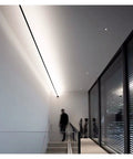 Effortlessly Sleek Modern Linear LED Wall Sconces With Remote Control For Cozy Bedroom And Living Room Vibes A Total Game Changer For Your Glow Up In Black Finish Dimmable Lighting illuminating a modern staircase.