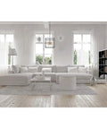 Living room with Cirrus Six Light Chandelier With Vintage Brass Finish And Clear Glass Rods over a modern white sectional sofa