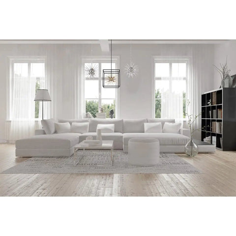 Living room with Cirrus Six Light Chandelier With Vintage Brass Finish And Clear Glass Rods over a modern white sectional sofa