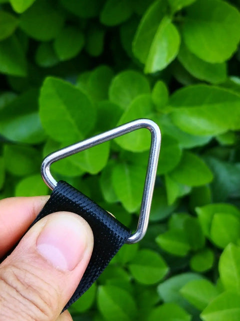 Hand holding Marine Grade Stainless Steel 316 Triangle Ring Buckle Welded V Shaped Ring against green leaves background.