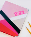 Compact White Label Maker Bundle With Four Tape Rolls For Hassle Free Home And Office Storage Featuring Dead Simple One Touch Keys Quick Print Templates And No Sweat Setup Design For Everyday Clutter Solutions Just Great on a colorful notebook with pencils.