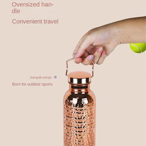 Hand holding Copper Water Bottle With Easy Temperature Control and Built Tough Leakproof Insulated Design