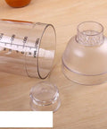 Clear Plastic Cocktail Shaker With Measurement Scale 33 Oz Handheld Drink Mixer showing lid and scale markings on wood surface