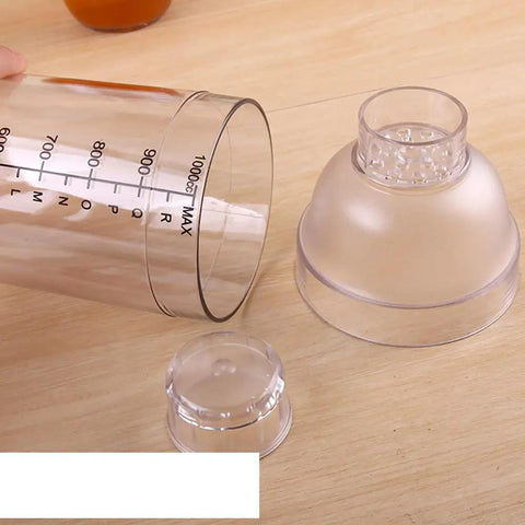Clear Plastic Cocktail Shaker With Measurement Scale 33 Oz Handheld Drink Mixer showing lid and scale markings on wood surface