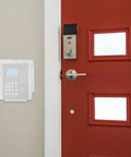 Waterproof Doorbell Rain Cover For Time Attendance And Fingerprint Devices PVC Protective Weatherproof Cover No Fuss Easy Install Keeps Rain And Snow Off Electronics And Components In Outdoor Settings on wall by red door