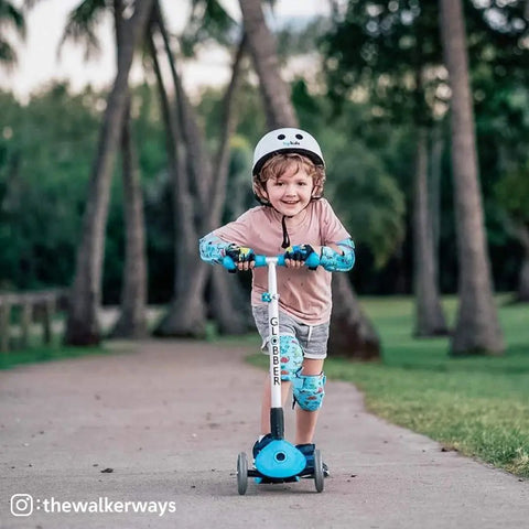 Kid Friendly Knee And Elbow Pad Set With Pro Grade Bike Gloves For Ages 2-11 All Day Fun Flexible Impact Resistant Protective Gear For Balance Bikes Roller Skating And Skateboarding Dinosaur Design Small on child riding scooter outdoors.