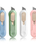 Four PSC box cutters in blue, green, white, and pink with retractable blades and beige slides.