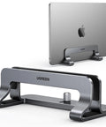 Vertical Laptop Stand For Desk, Aluminum Holder showing front and side view, holding MacBook, space-saving mount in sturdy gray