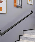 12 Ft Matte Black Wrought Iron Wall Mount Railing Beast Mode Heavy Duty Non Slip Handrail for Stairs Porch Deck Supports 440 Lbs Corrosion Resistant Indoor Outdoor Banister Bad Ass Grip mounted on staircase wall.